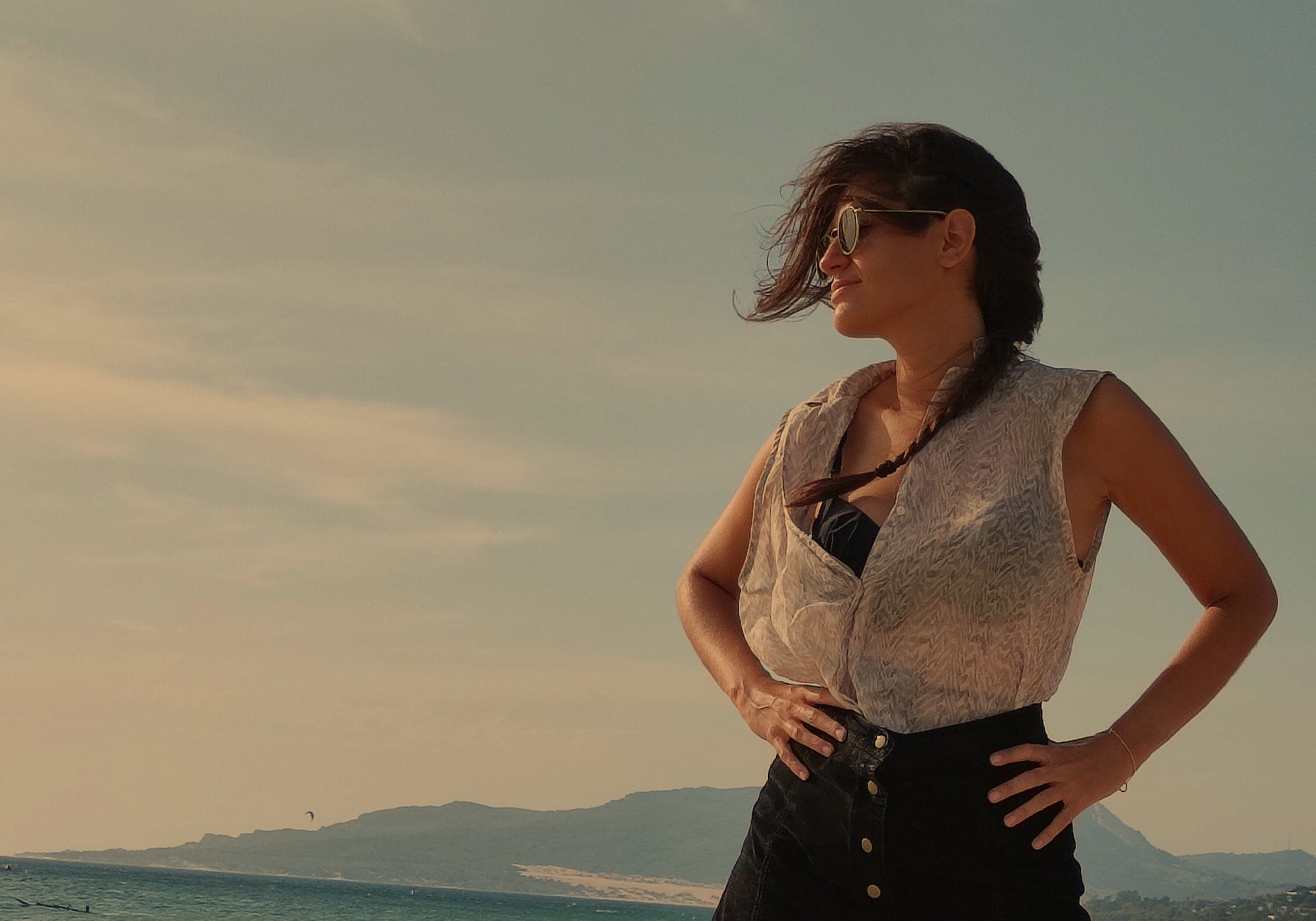 Woman standing on a beach with mountains in the background