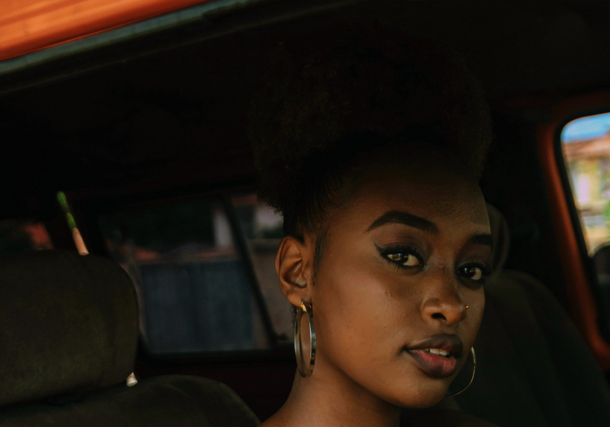Woman sitting inside a vehicle with a dark interior